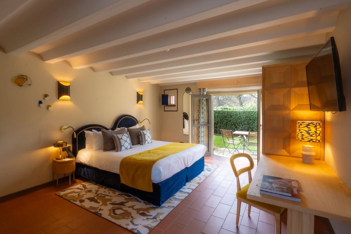Une chambre à coucher avec un lit, des tables de chevet, un bureau et une chaise.