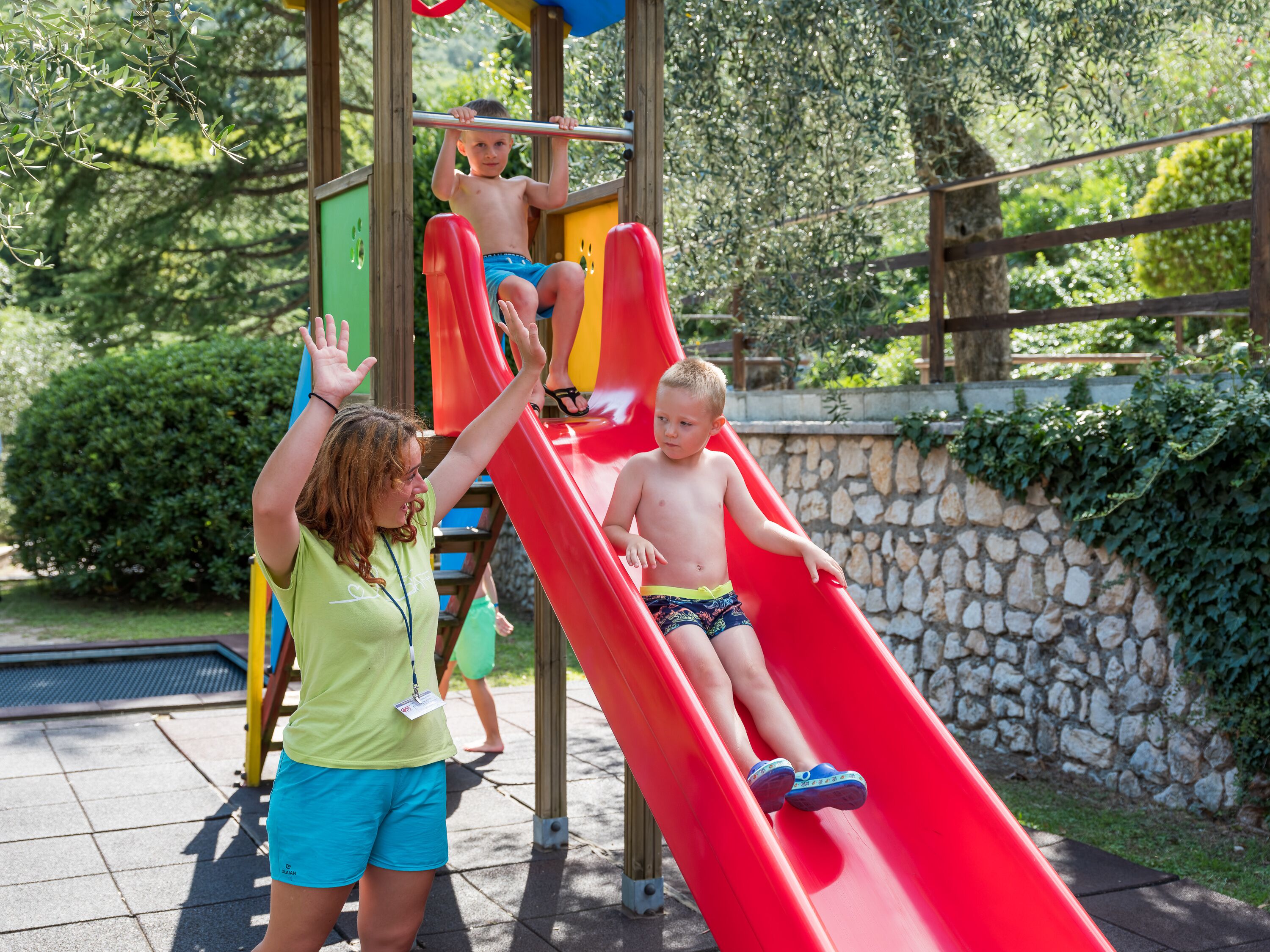 Un parque infantil con un tobogán rojo y una estructura para escalar.