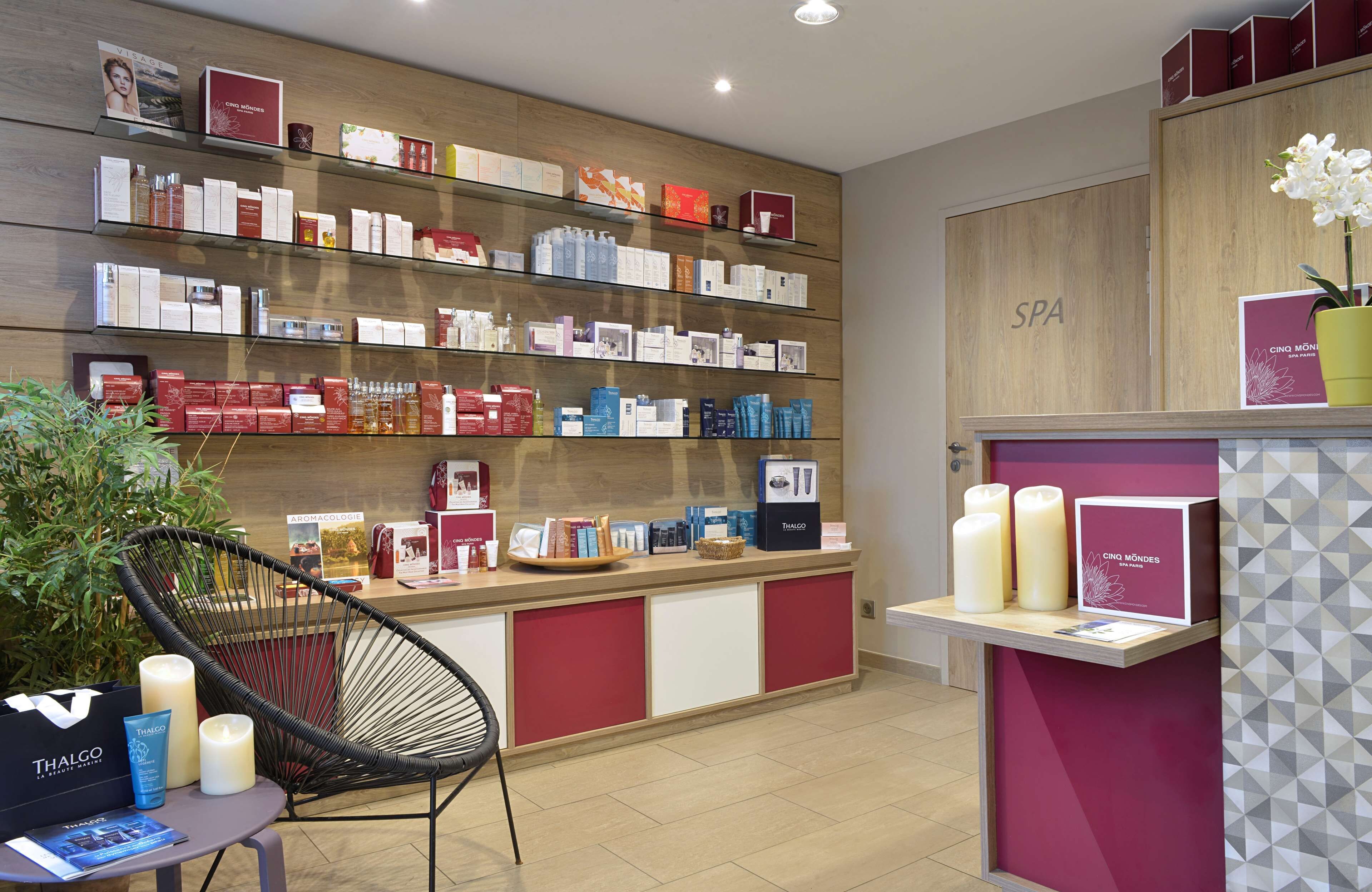 A spa area with shelves of products, a reception desk, and a chair.
