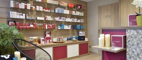 A spa area with shelves of products, a reception desk, and a chair.