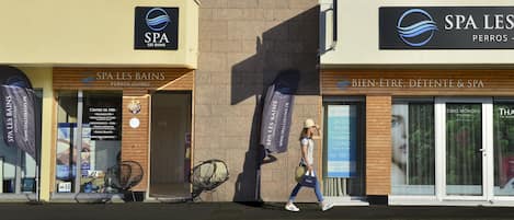 A spa named SPA LES BAINS with a wooden facade and large glass doors.