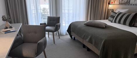 Une chambre d’hôtel moderne, équipée d’un lit, d’un bureau et d’une chaise.