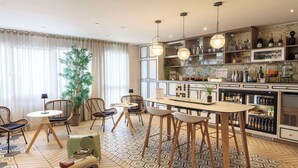 A modern bar area with a bar counter, seating, and a variety of bottles and glasses. - Best Western Les Bains Hôtel & SPA Perros-Guirec (Perros-Guirec)