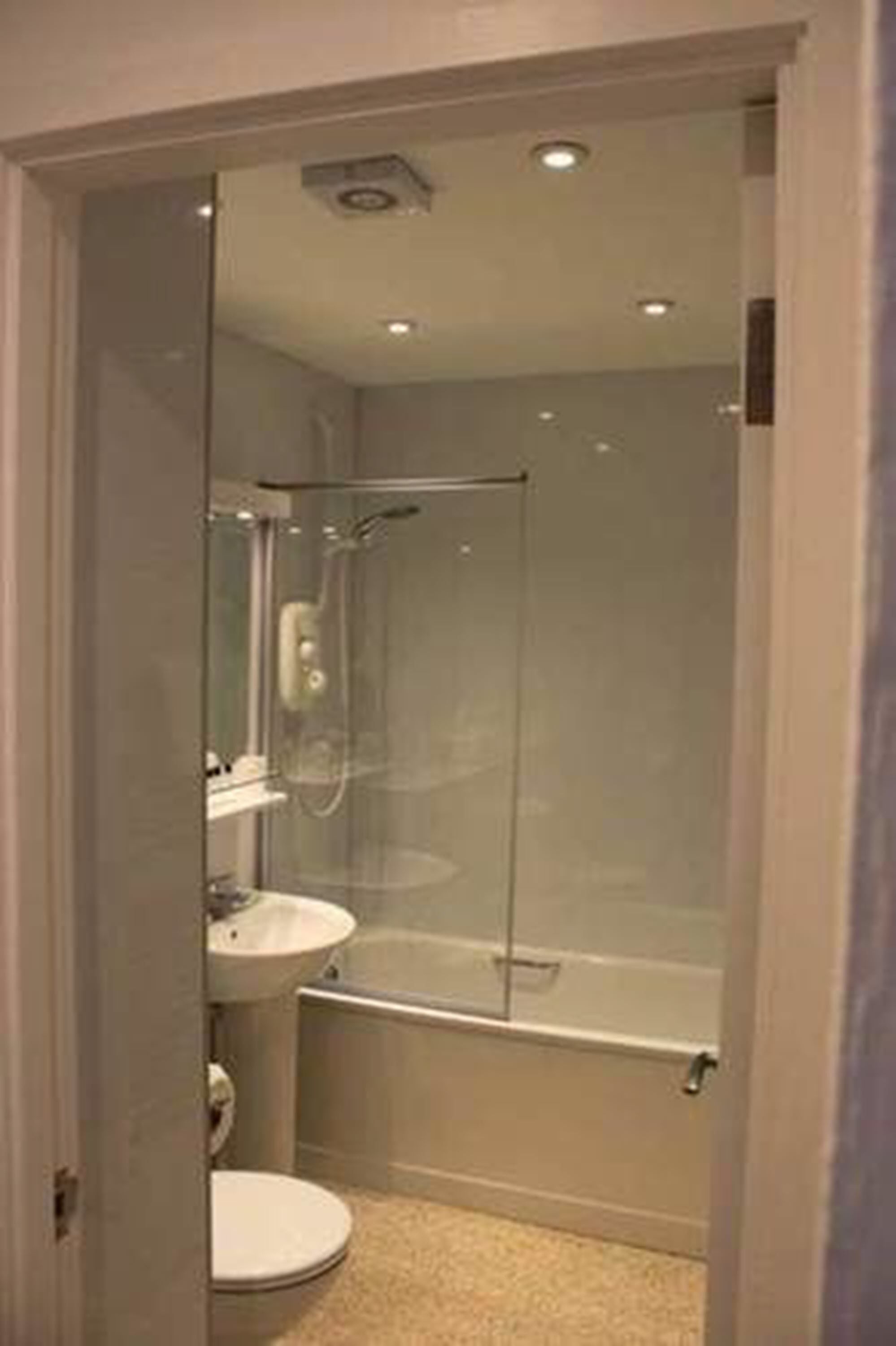 Ein modernes Badezimmer mit einer Duschkabine, einer Toilette und einem Waschbecken.