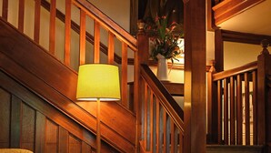 A wooden staircase with a lamp and a chair in a warmly lit room. - Renvyle House Hotel & Resort (Renvyle)