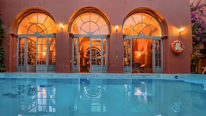 Piscina com janelas em arco e reflexo do seu interior.