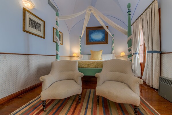 A room with a bed, two armchairs, a striped rug, and a canopy bed. - Casa Palacio de Carmona (Carmona)