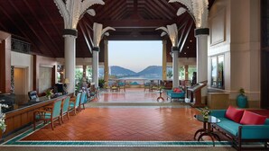 A spacious lobby with a reception desk, seating area, and a view of the mountains.