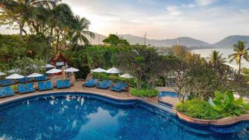 Una piscina al aire libre, sombrillas, tumbonas