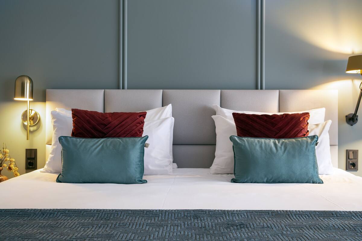 A neatly made bed with a patterned bedspread, two pillows, and a headboard.