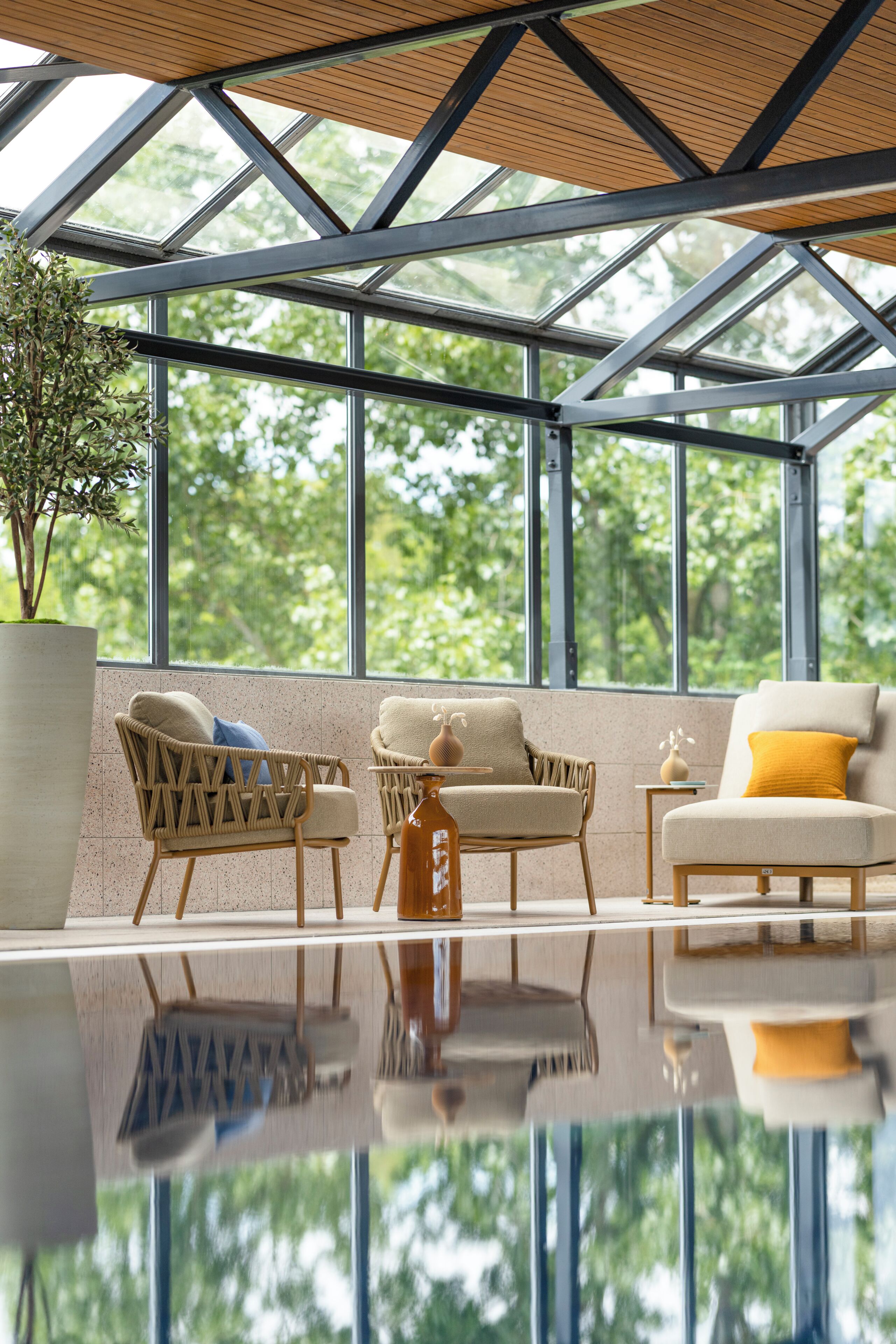 Un interior moderno con ventanas amplias, muebles de mimbre y un suelo reflectante.