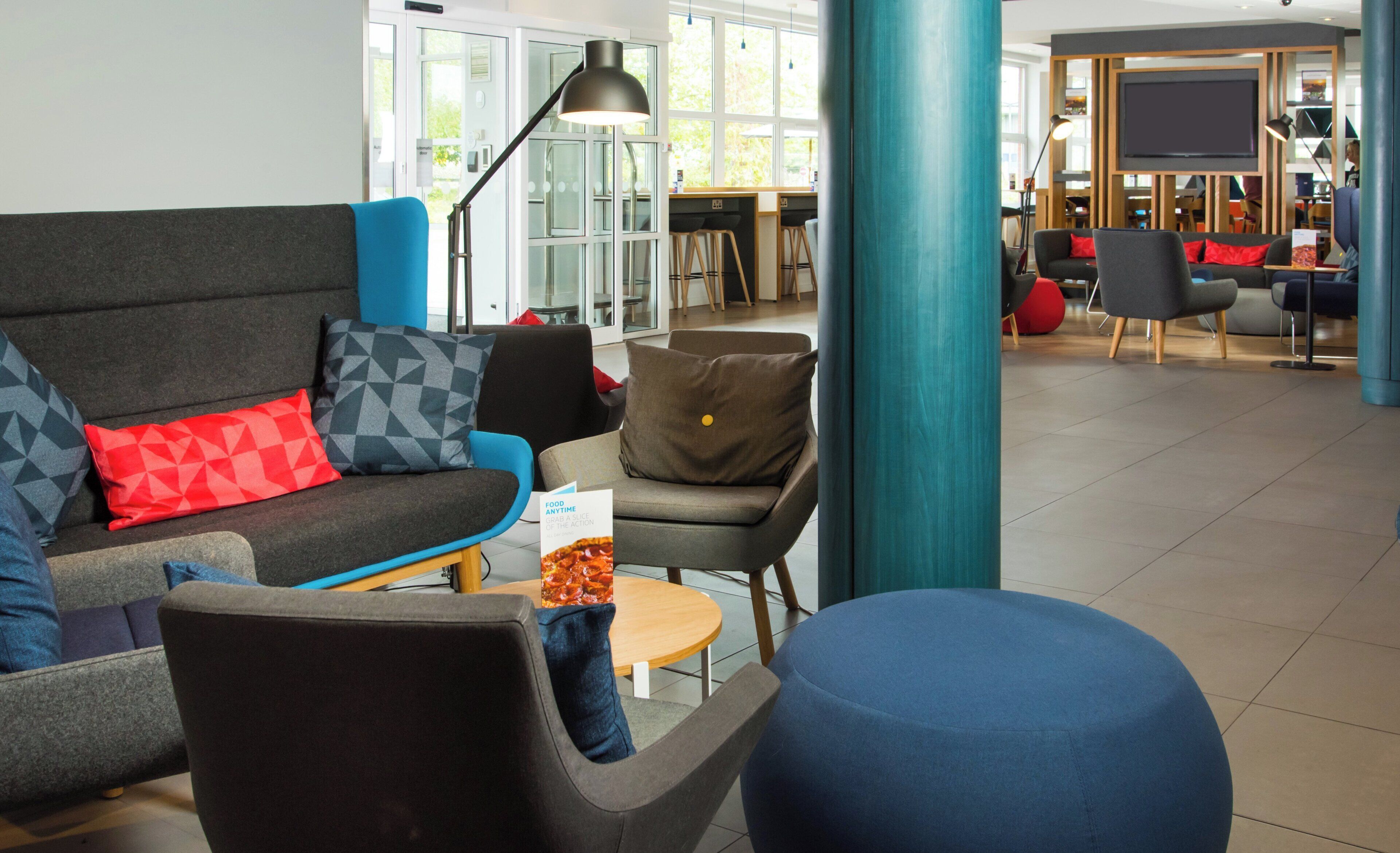 A modern lounge area with seating arrangements, a coffee table, and a television screen.