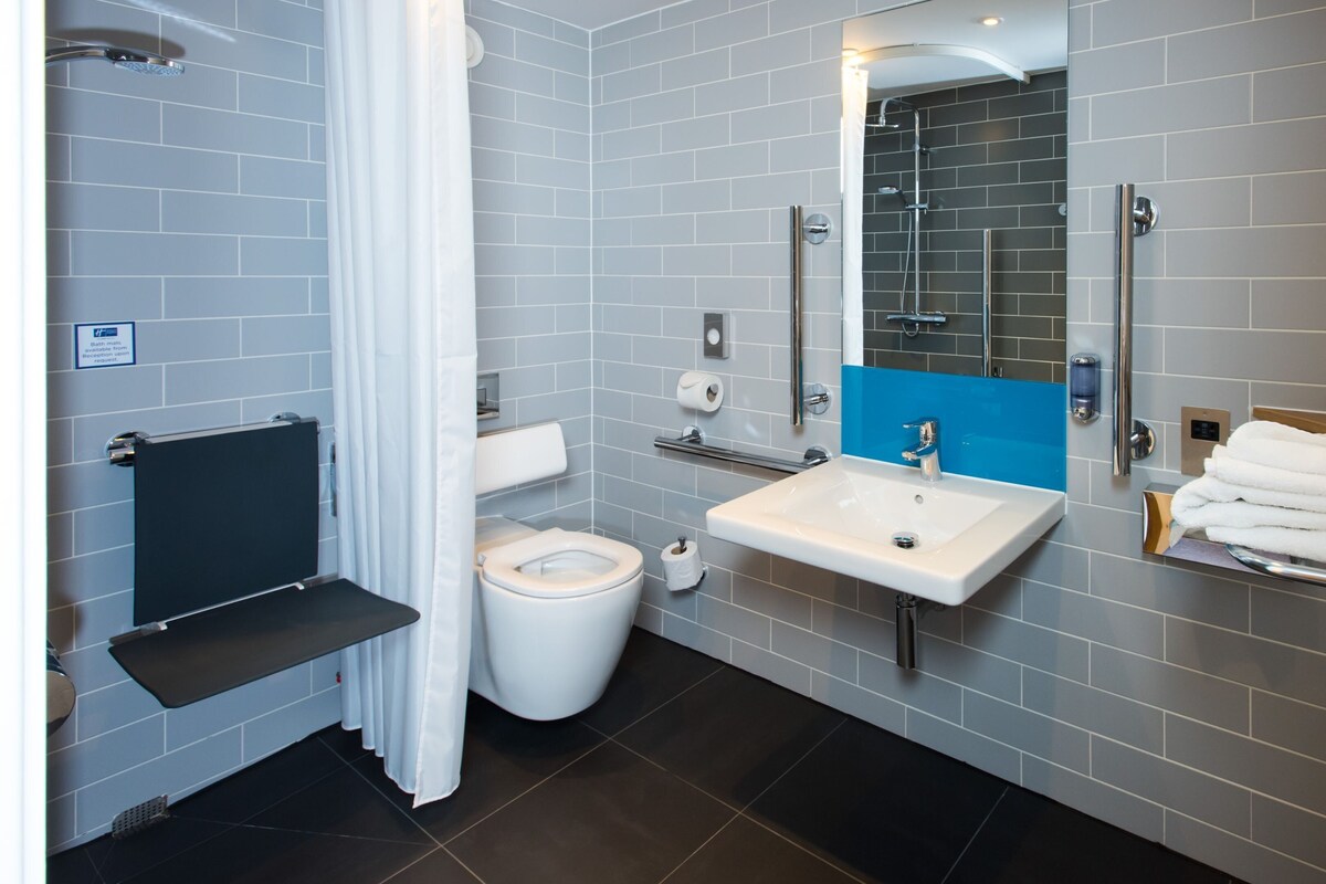 Un baño moderno con inodoro, lavamanos y ducha.