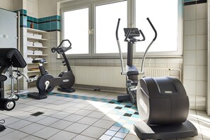 A gym with exercise equipment, a window, and a tiled floor. - Best Western Hotel Im Forum Muelheim (Muelheim an der Ruhr)
