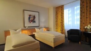 A hotel room with two beds, a desk, a chair, and a framed picture on the wall. - Best Western Hotel Im Forum Muelheim (Muelheim an der Ruhr)