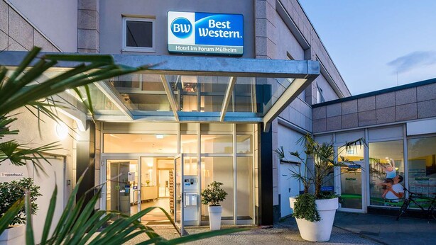 The exterior of Best Western Hotel im Forum Mulheim, featuring a modern facade, large glass entrance, and potted plants. - Best Western Hotel Im Forum Muelheim (Muelheim an der Ruhr)
