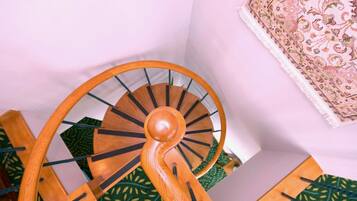Una escalera de caracol de madera con un suelo de alfombra estampado en verde.