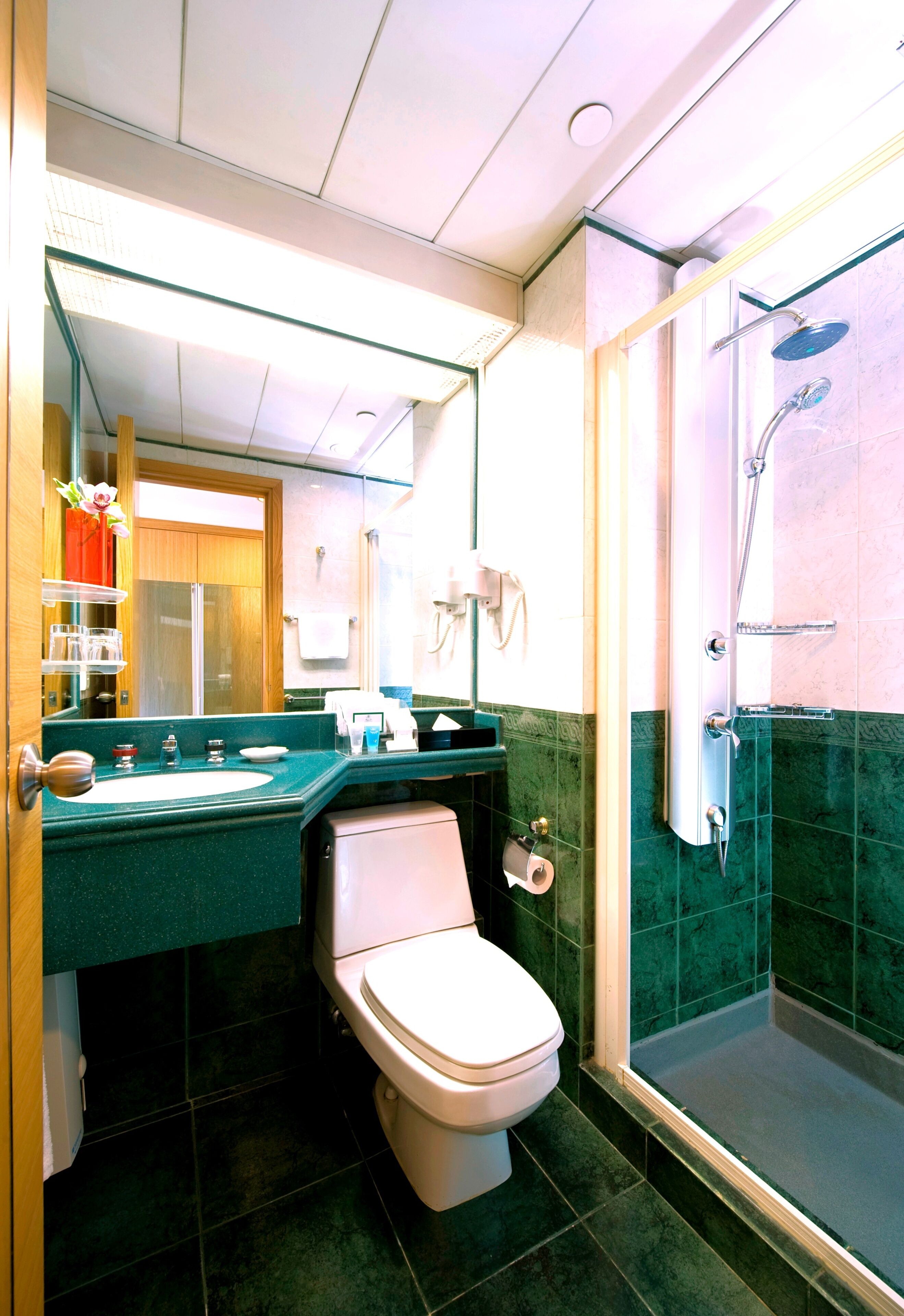 A bathroom with a sink, toilet, and a glass-enclosed shower area.