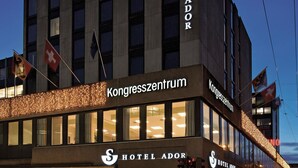 Un hotel con un letrero llamativo que dice 'HOTEL ADOR' y 'Kongresszentrum'.