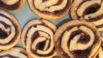 A collection of cinnamon rolls arranged closely together.