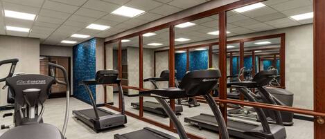 A gym with multiple treadmills, stationary bikes, and a rowing machine.