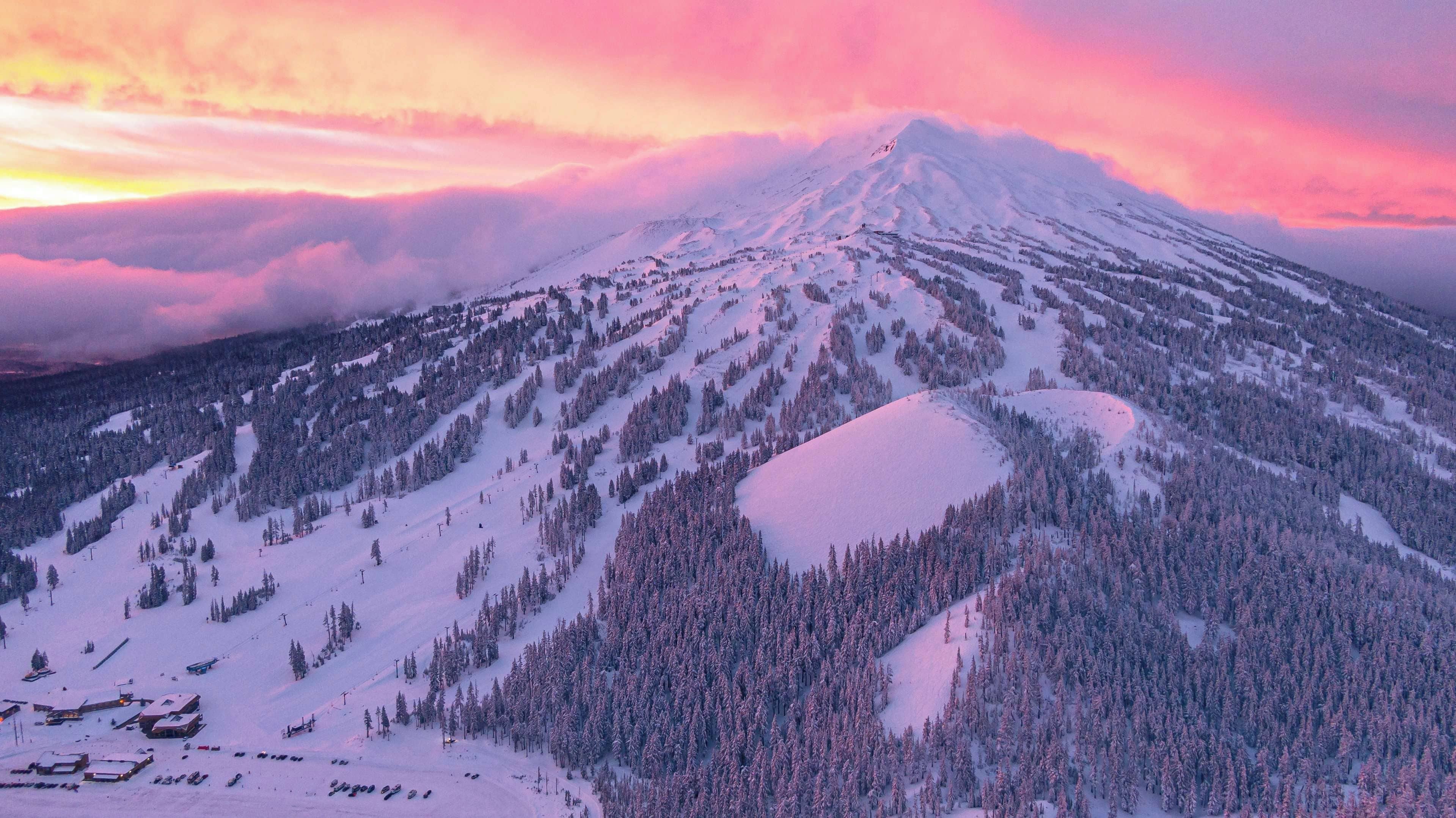 A snow-covered mountain with a ski resort at its base.