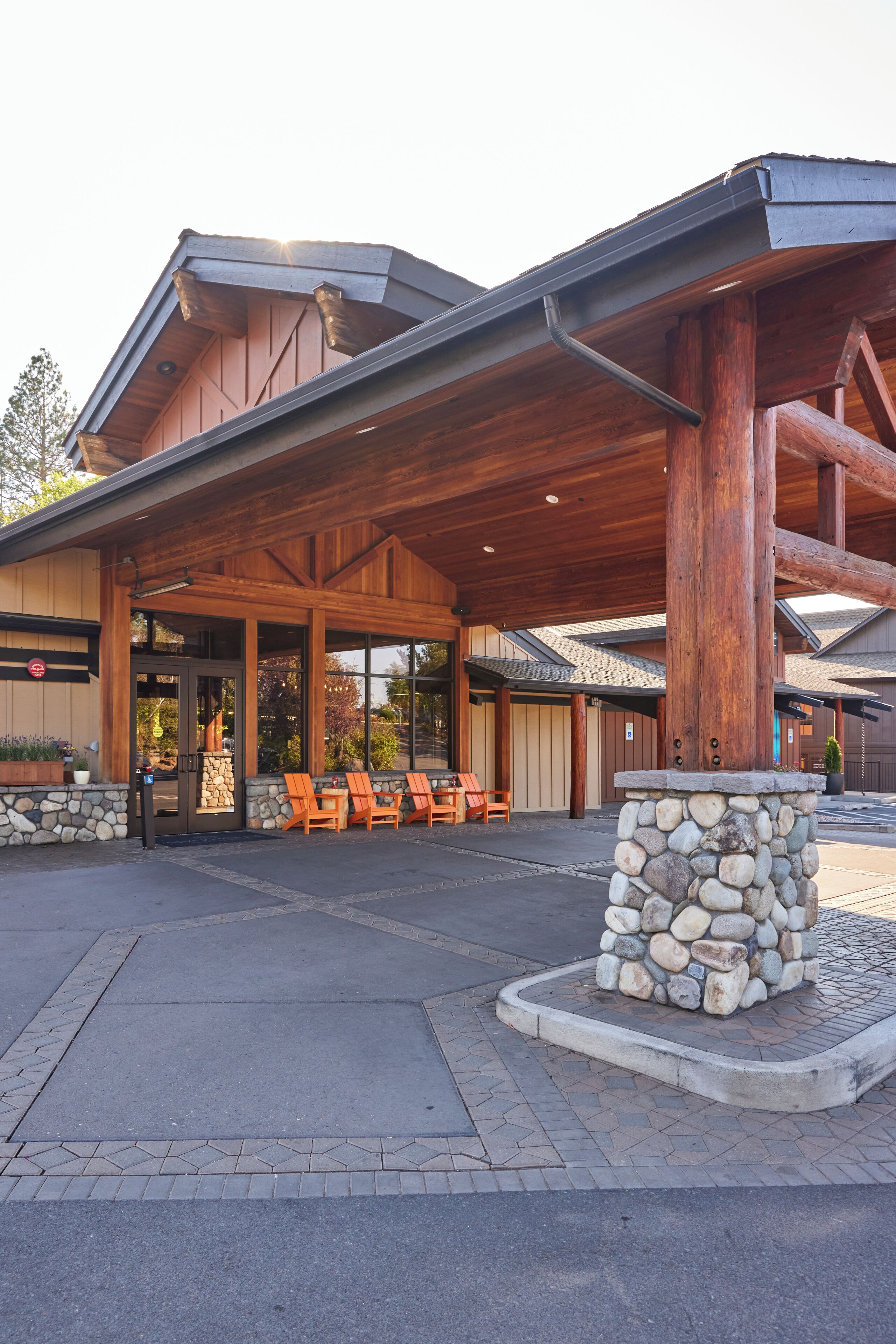 Eine Lodge mit überdachter Außensitzgruppe und Säulen aus Stein.