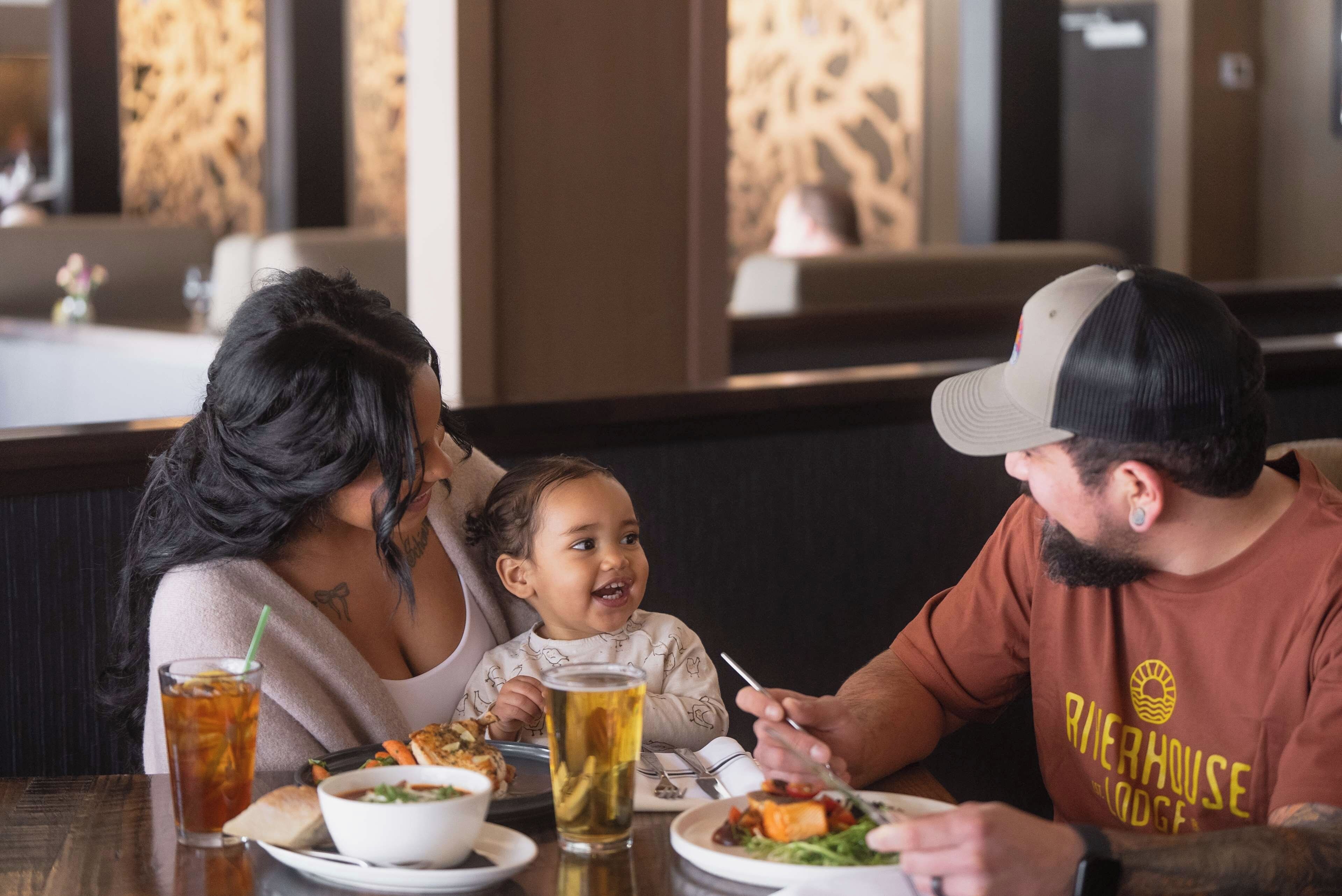 Una familia cenando en un restaurante con ambiente relajado.