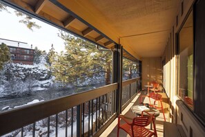 A balcony with a view of a snow-covered landscape and a river. - Riverhouse Lodge (Bend)