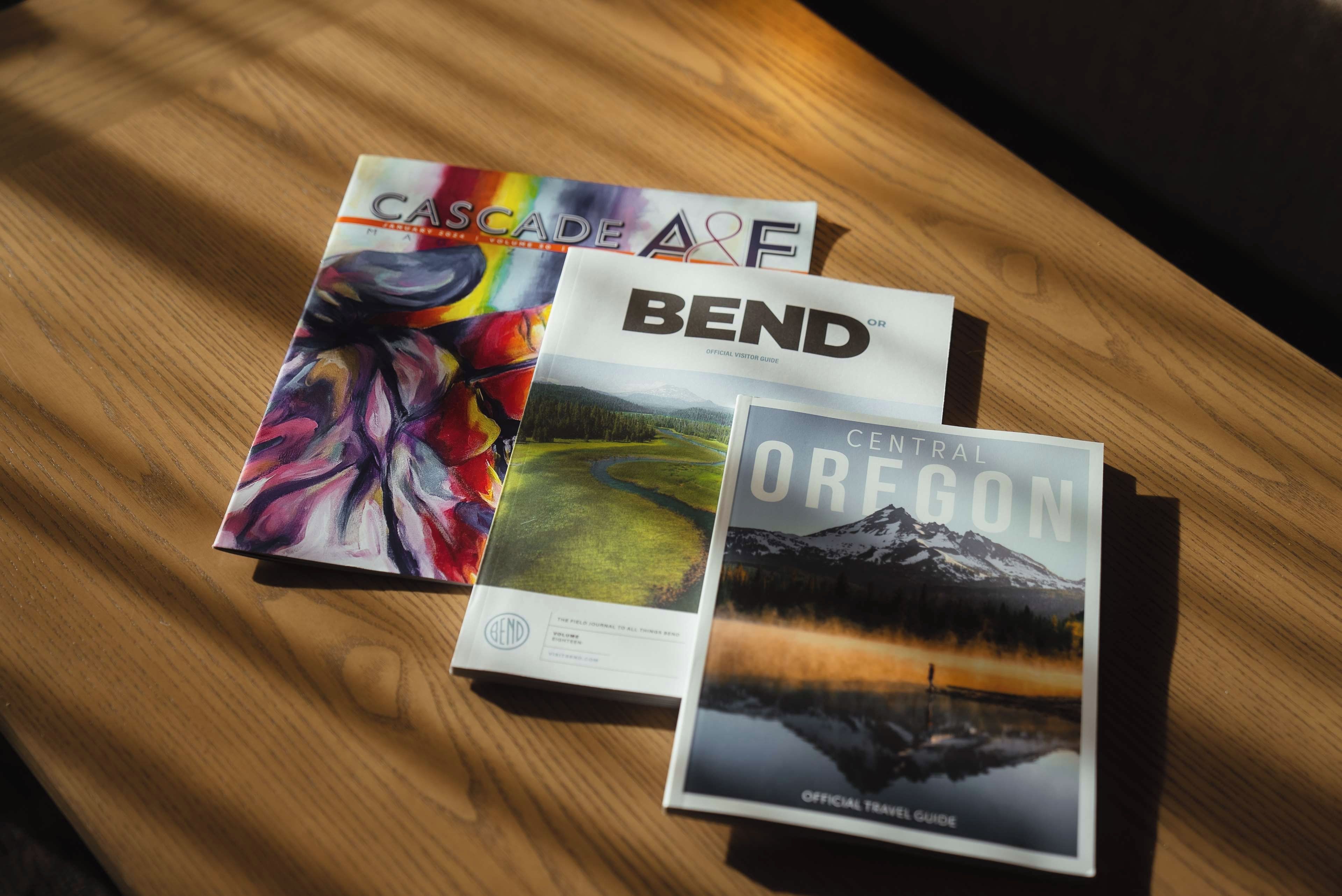 Three travel guides on a wooden surface.