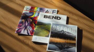 Three travel guides on a wooden surface.