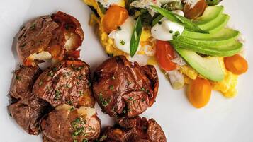 Un plato de comida con huevos, aguacate y carne.