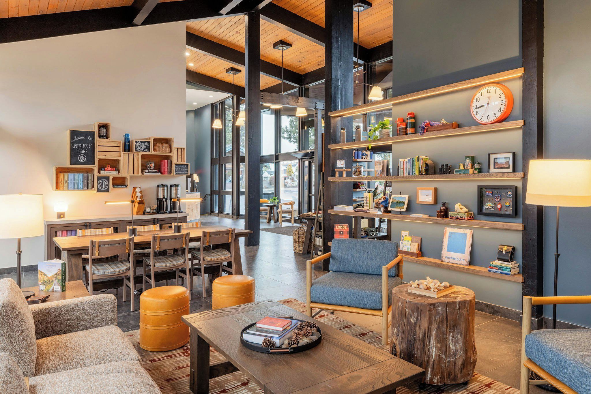 Un espacio lounge acogedor con asientos, una estación de café y estantes con libros y objetos decorativos.