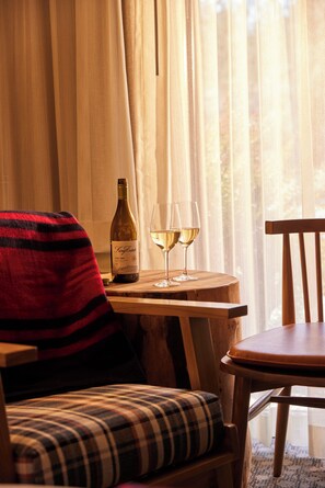 Una habitación acogedora con una mesa de madera, una botella de vino y dos copas.