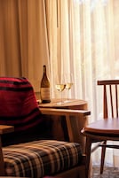 Une pièce chaleureuse avec une table en bois, une bouteille de vin et deux verres.