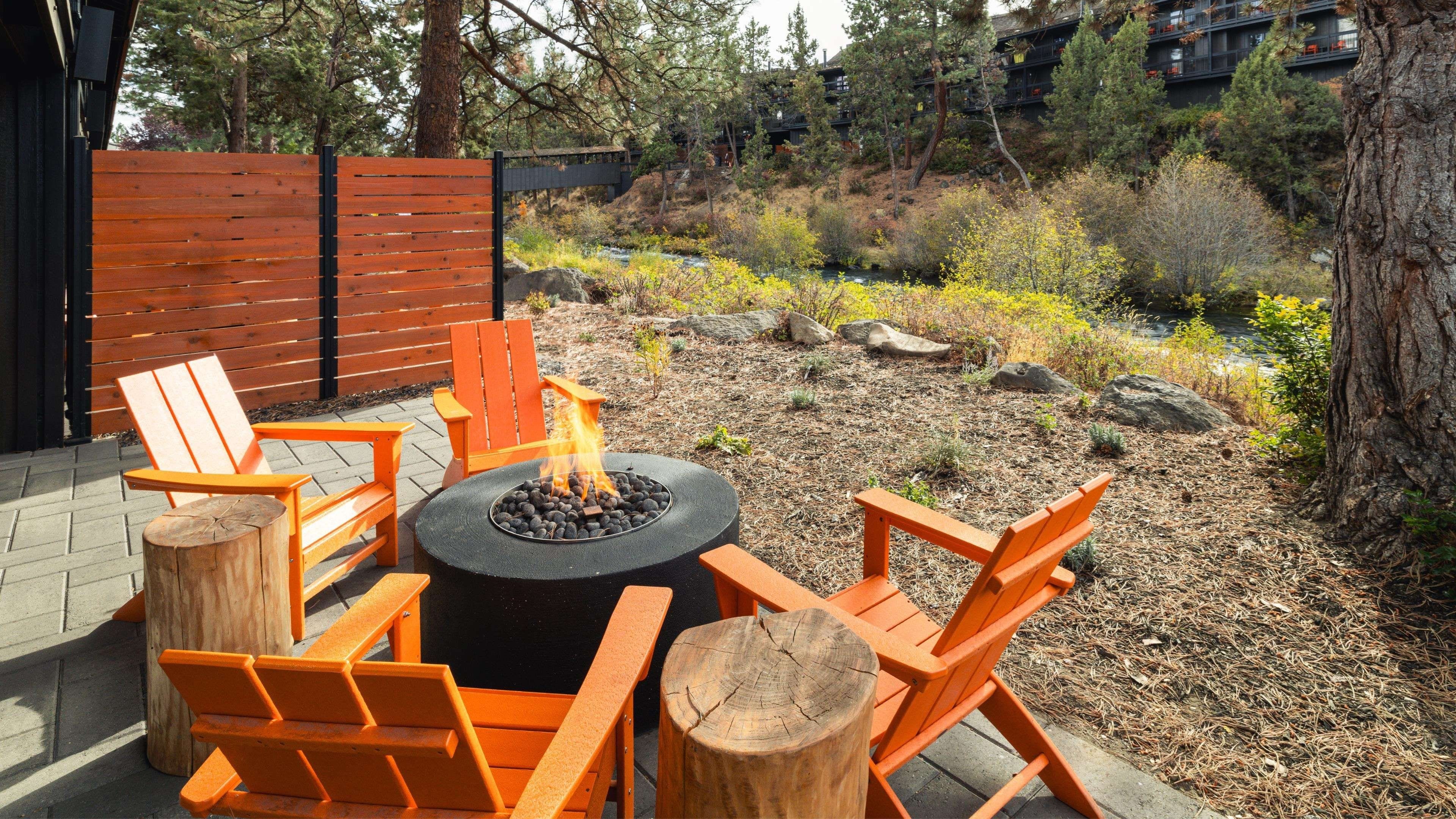 A fire pit with chairs and a table in an outdoor setting.