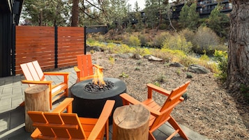 A fire pit with chairs and a table in an outdoor setting.