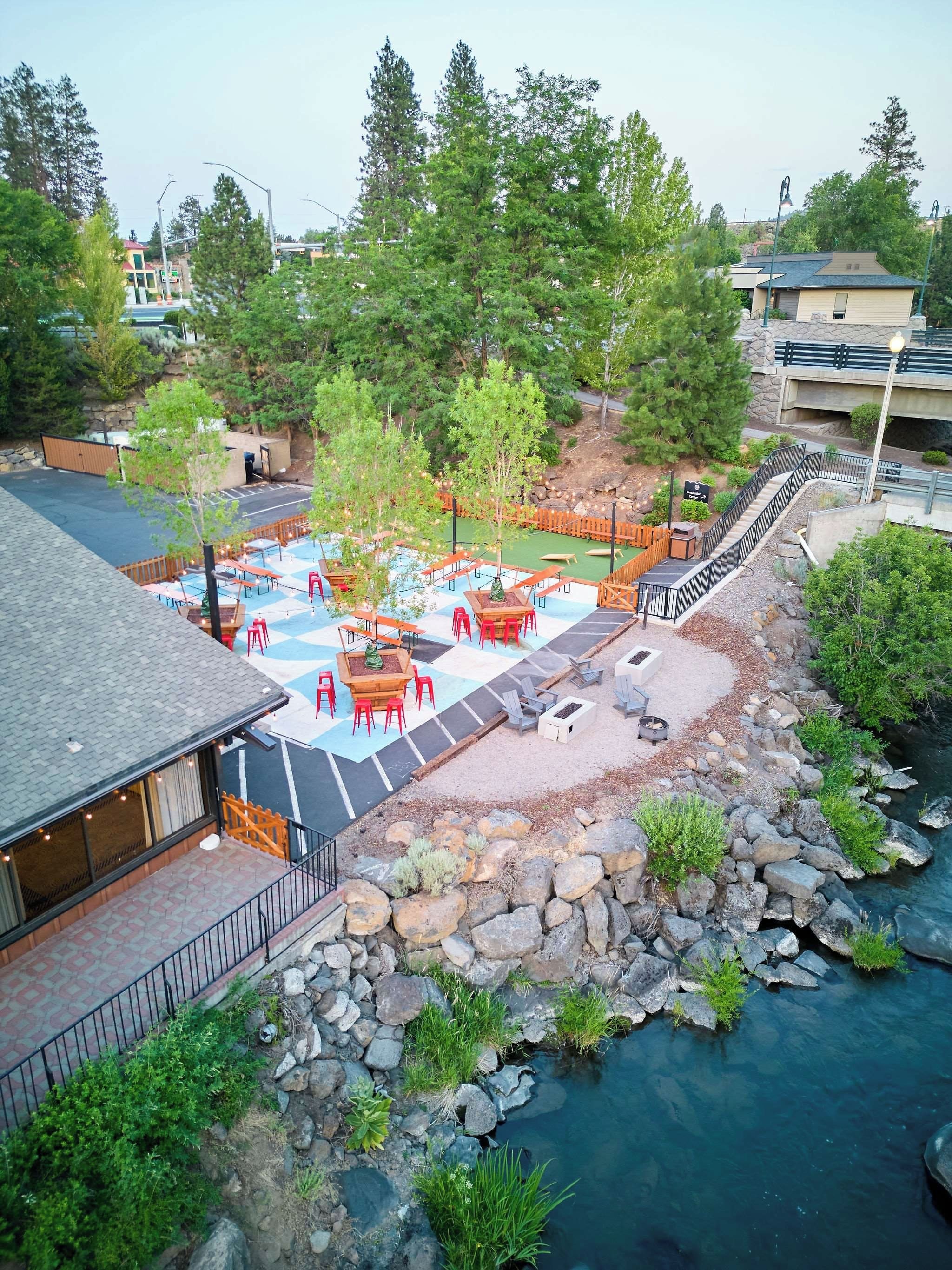 Une terrasse sur le toit avec des sièges extérieurs, une petite piscine et une vue sur une rivière.
