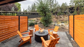 An outdoor seating area with wooden chairs and a central fire pit. - Riverhouse Lodge (Bend)