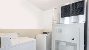 A laundry area with a washing machine, a dryer, and an ice dispenser.