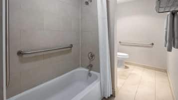 Un baño con bañera, inodoro y zona de ducha.