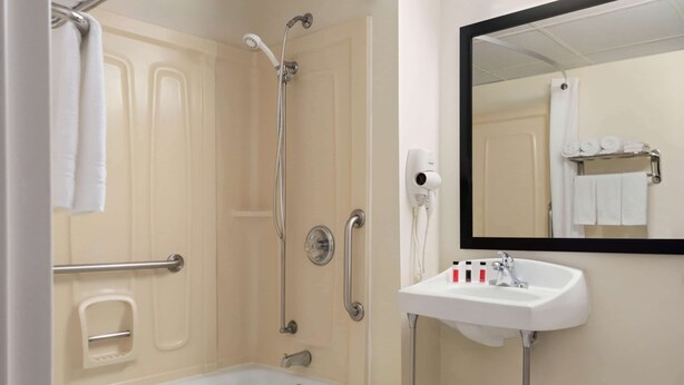 A bathroom with a bathtub, a shower, a sink, and a mirror. - Super 8 by Wyndham Liverpool/Syracuse North Airport (Liverpool)