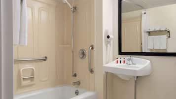A bathroom with a bathtub, a shower, a sink, and a mirror.