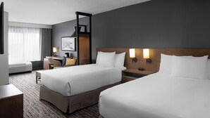 A hotel room with two beds, a desk, a chair, a TV, and a window with curtains. - Hyatt Place Tempe Phoenix Airport (Tempe)
