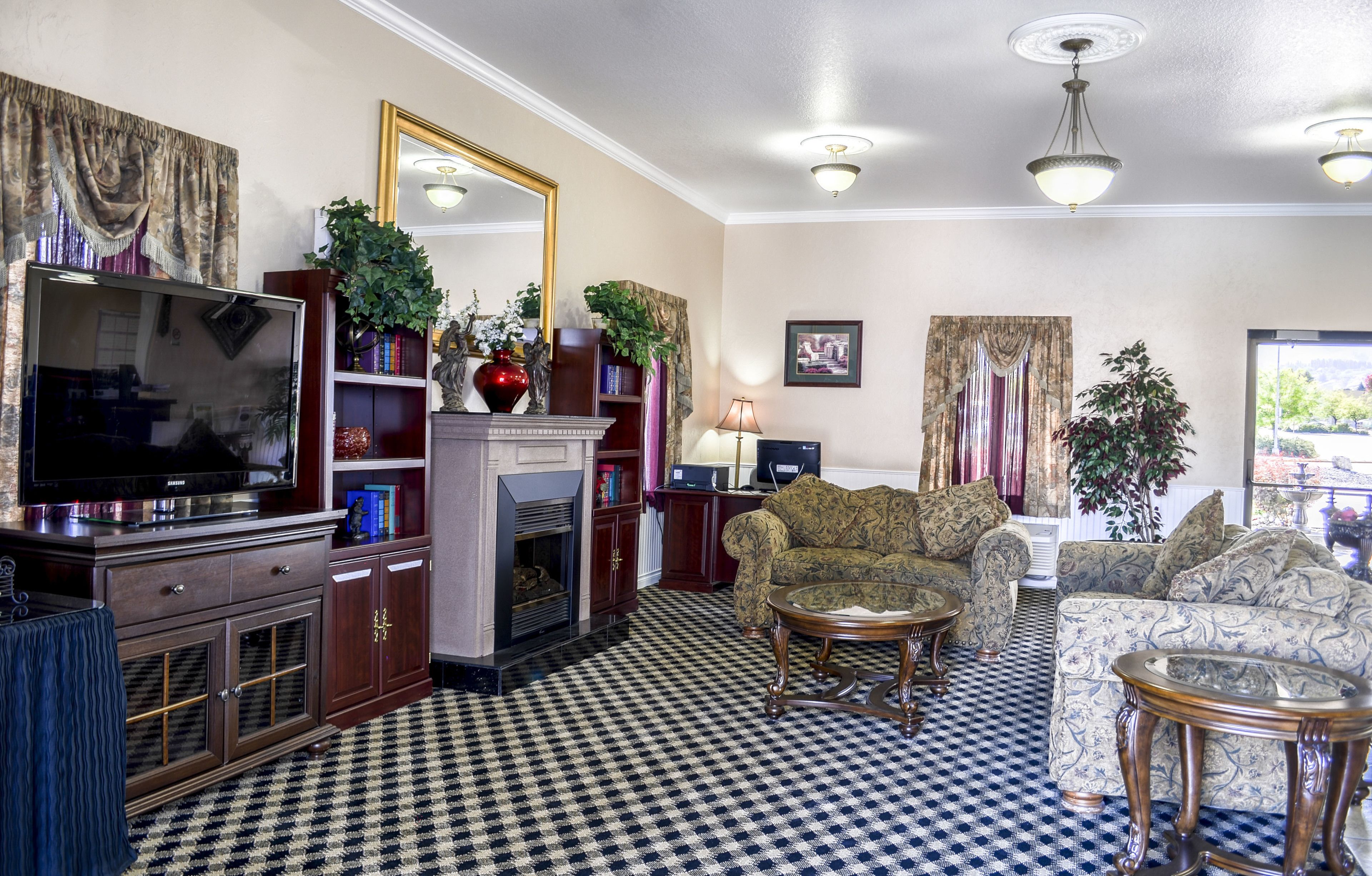 A living room with a checkered floor, a fireplace, a television, a sofa, and a coffee table.