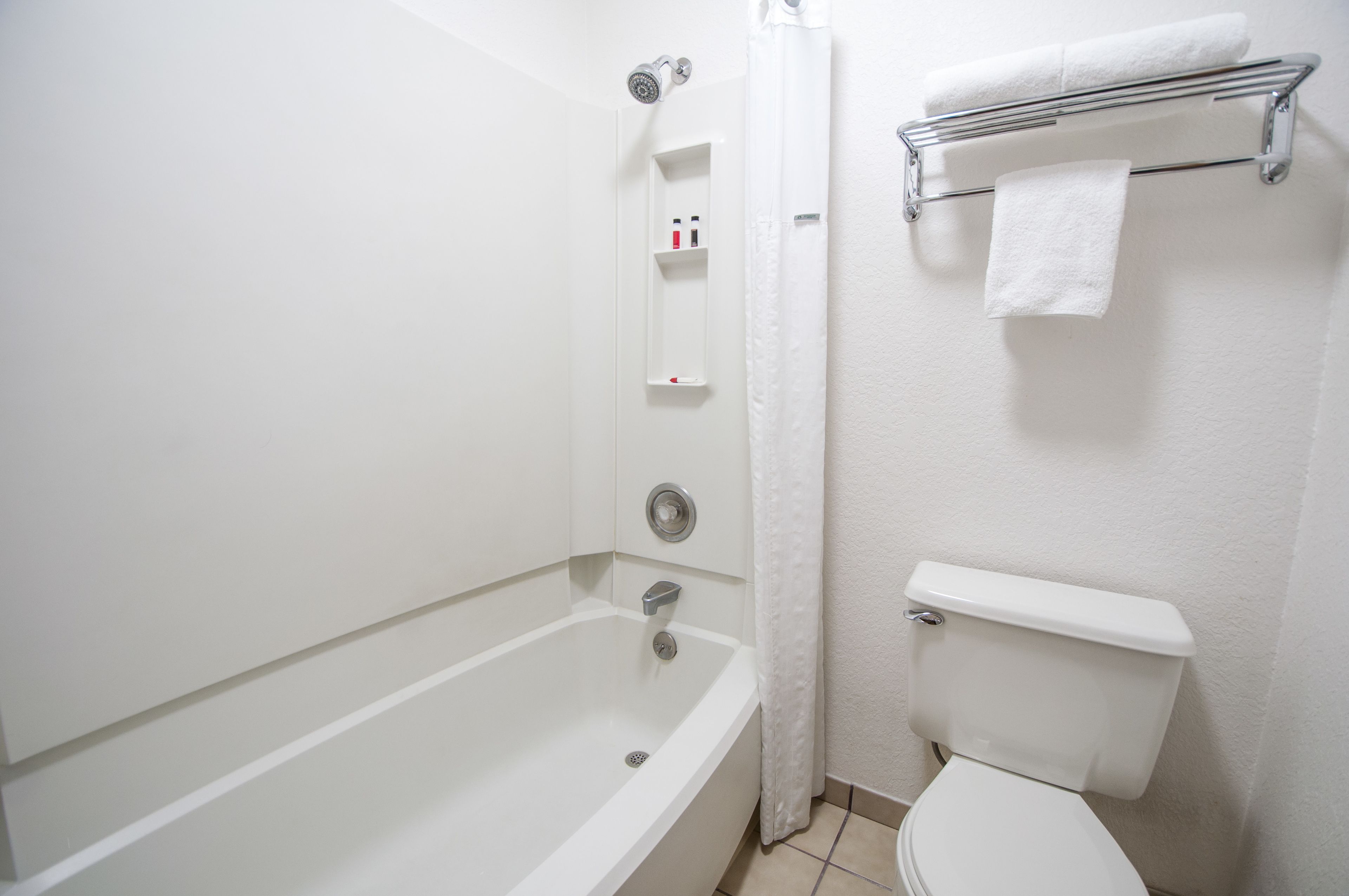 Ein Badezimmer mit Badewanne, Toilette und Handtuchhalter.