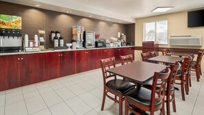 A restaurant with a counter, chairs, and tables.