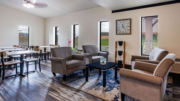 Un salón comedor amplio con una gran mesa, asientos cómodos y ventanas que ofrecen vistas al exterior.