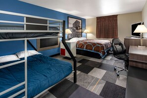 Cozy accommodations feature a bunk bed and single bed, a desk with chair, and a television.