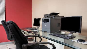 A home office setup with a desk, two monitors, a printer, a keyboard, a mouse, and a chair.